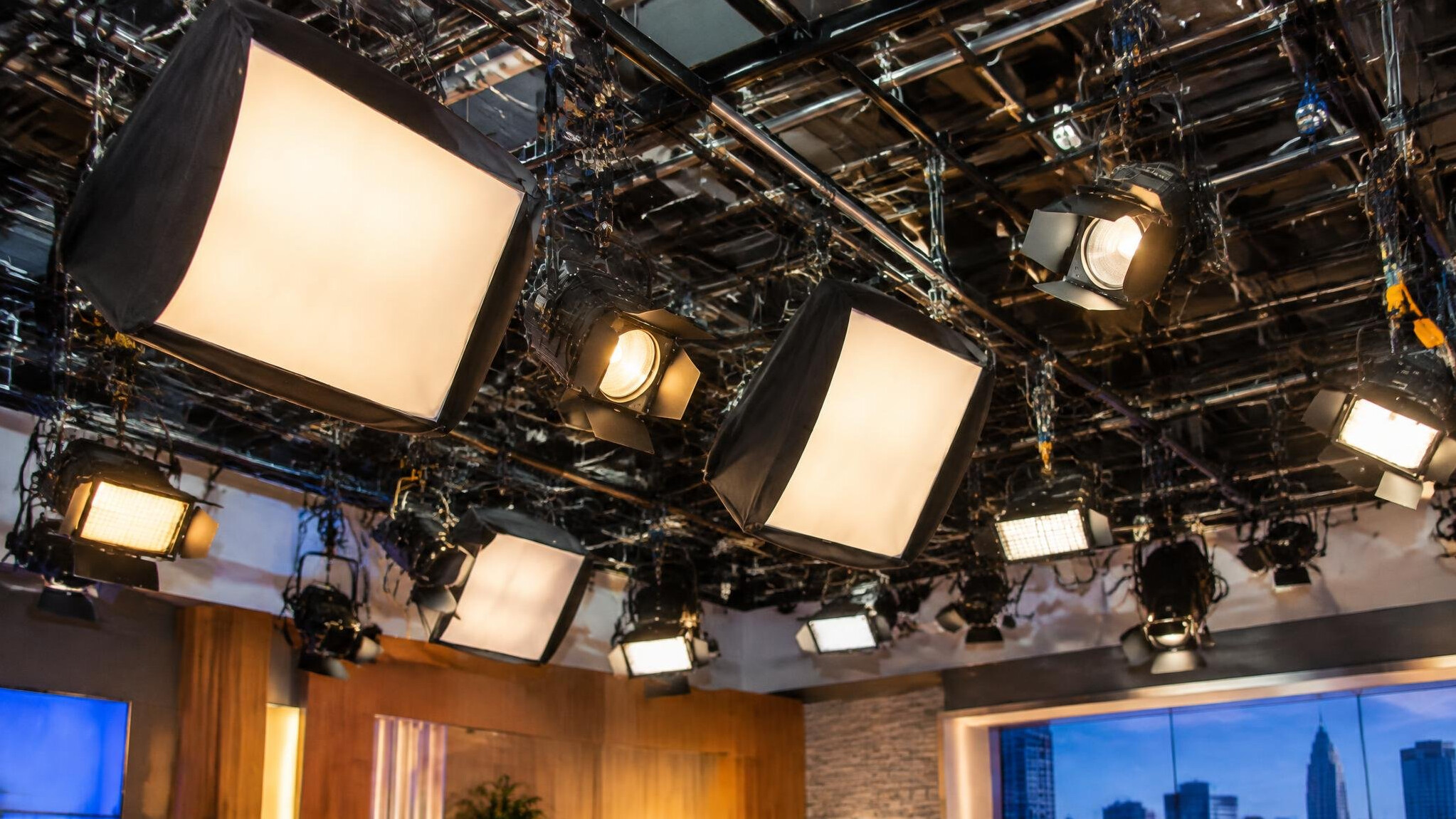 Rig of studio lighting fixtures suspended above a television set